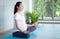 Pregnant women are doing yoga for good health in the living room. Asian pregnant woman practicing yoga on mat