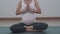 Pregnant women perform yoga poses starting put the hands on knee and change to Hand in the middle of the chest. Practicing yoga pr