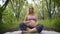 Pregnant yoga in the lotus position. in the park on the grass on the mat, doing exercises, breathing, stretching