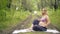 Pregnant yoga in the lotus position. in the park on the grass on the mat, doing exercises, breathing, stretching