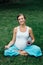 Pregnant yoga woman in the lotus position with mat portrait in park on the grass, breathing, stretching, statics.