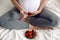 Pregnant young girl holding strawberries