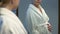 Pregnant young woman in bathrobe looking at tummy in mirror, baby expectation