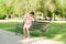 A pregnant young woman on a bench sitting in the park and holds on to the stomach which hurts. Pregnancy and motherhood. back pain