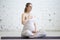 Pregnant young woman doing prenatal yoga. Pranayama