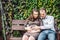 A pregnant young woman and her husband. A happy family sitting on a swing, holding belly. pregnant woman relaxing in the park.