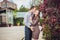 A pregnant young woman and her husband. A happy family standing at the red autumn hedge, holding belly. pregnant woman relaxing in