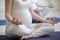 Pregnant young women doing prenatal yoga. Close-up of torso