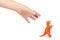 Prehistoric dinosaur rubber toy with kid hand, isolated on white background