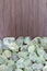 Prehnite heap jewel on half brown varnished wood texture