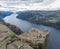 Preikestolen massive cliff at fjord Lysefjord, famous Norway viewpoint with group of tourists and hikers.Moody autumn