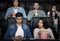 Premiere night. Millennial man checking mobile phone while watching film in movie theater