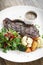 Premium beef steak with steamed vegetables meal on white plate