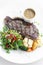 Premium beef steak with steamed vegetables meal on white plate