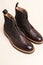 Premium Dark Brown Grain Brogue Derby Boots Made of Calf Leather with Rubber Sole Placed Over Beige