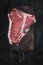 Premium Dry Aged Raw T-bone Steak on Rustic Kitchen Chopping Board