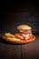 Premium grilled beef hamburger with bacon, cheese and French fries. Delicious American burger on wooden background.