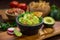 Premium handmade Guacamole from fresh organic avocados with chips on a table with pico de gallo salsa