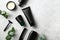 Premium men\\\'s SPA cosmetics set with green plants on stone table. Bath beauty products in black packaging