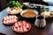 Premium Rare Slices Kurobuta Black Pig pork with high-marbled texture on circle wooden plates served with vegetable set.