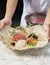 Premium Sashimi garnished with edible flowers in ceramic plate, Sashimi plate served by Japanese chef