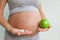 Prenatal care. Pregnant woman with pills and apple. prenatal vitamins
