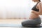 Prenatal Yoga. Smiling Pregnant Woman Sitting On Fitness Mat And Touching Belly