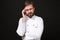 Preoccupied tired young bearded male chef cook or baker man in white uniform shirt posing isolated on black background