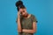 Preoccupied young african american woman girl in casual t-shirt posing isolated on bright blue wall background in studio