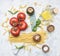 Preparation of appetizing Italian pasta, with tomatoes, basil, and oil in a decanter, spices seasonings on a white rustic back