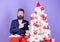 Preparation and celebration. Man bearded hipster wear formal suit near christmas tree. Checklist christmas preparation