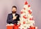 Preparation and celebration. Man bearded hipster wear formal suit near christmas tree. Checklist christmas preparation