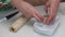 Preparation of cinnabons. A woman cuts a cinnamon dough roll. Puts in a baking dish. The camera moves on a slider. Medium plan