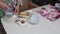 Preparation of cinnabons. A woman mixes cottage cheese and flour. The ingredients are laid out on the table. Medium plan