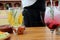 Preparation of citrus gin and tonic and red berries on wooden table, waitress serves food and drinks