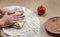 Preparation cookies with cinnamon, cottage cheese and apples on kraft paper. Female hands rolling dough in meals