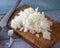 Preparation for cooking, chopped onions on a cutting board on a blue wooden table