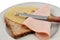 Preparation of a croque-monsieur with a slice of sandwich bread, ham and Emmental cheese on a plate with a knife