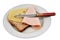 Preparation of a croque-monsieur with a slice of sandwich bread, ham and Emmental cheese on a plate with a knife on a white backgr
