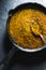 Preparation of curry paste in a cast-iron frying pan closeup. Indian food