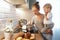 preparation of family breakfast. mother and baby son cook porridge in morning