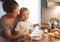 preparation of family breakfast. mother and baby son cook porridge in morning