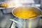 Preparation of the first course in the dining room. Soup or chowder is cooked in an aluminum pot on an electric stove