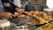 Preparation fresh delicious food at the night market, slow motion. Chef roasts seafood in a hot pan on the street