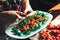 Preparation of fresh salad with tomato, ruccola on a kitchen table.