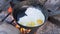 Preparation of Fried Eggs in a Frying Pan on the Bonfire in Forest. 4K