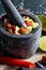 Preparation of guacamole in a traditional stone mortar with all its ingredients chopped avocados, lime, onion, tomatoes and chili