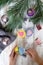 Preparation for the holiday. Hands make decorations on the Christmas tree