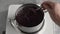 Preparation of homemade black elder syrup - cooking and stiring crushed elderberries