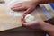 Preparation of homemade fruit dumplings with plums. Czech specialty of sweet good food. Dough on kitchen wooden table with hands